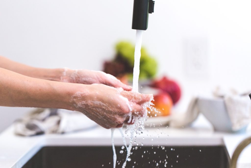 Person washing hands in sink using new faucet