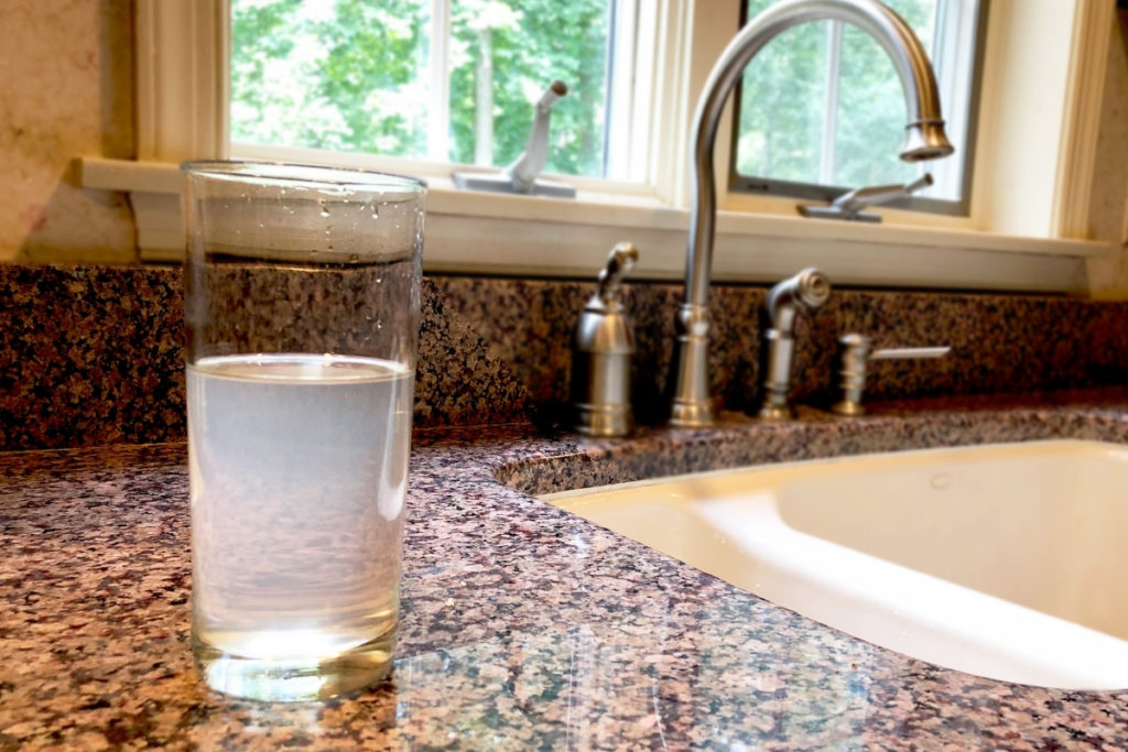 glass of cloudy water on counter that needs water filter repair