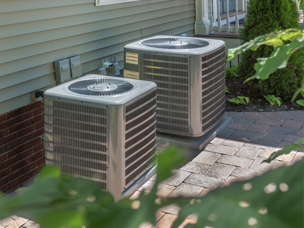 Two air conditioners outside of a home