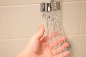 Homeowner running hand under shower water