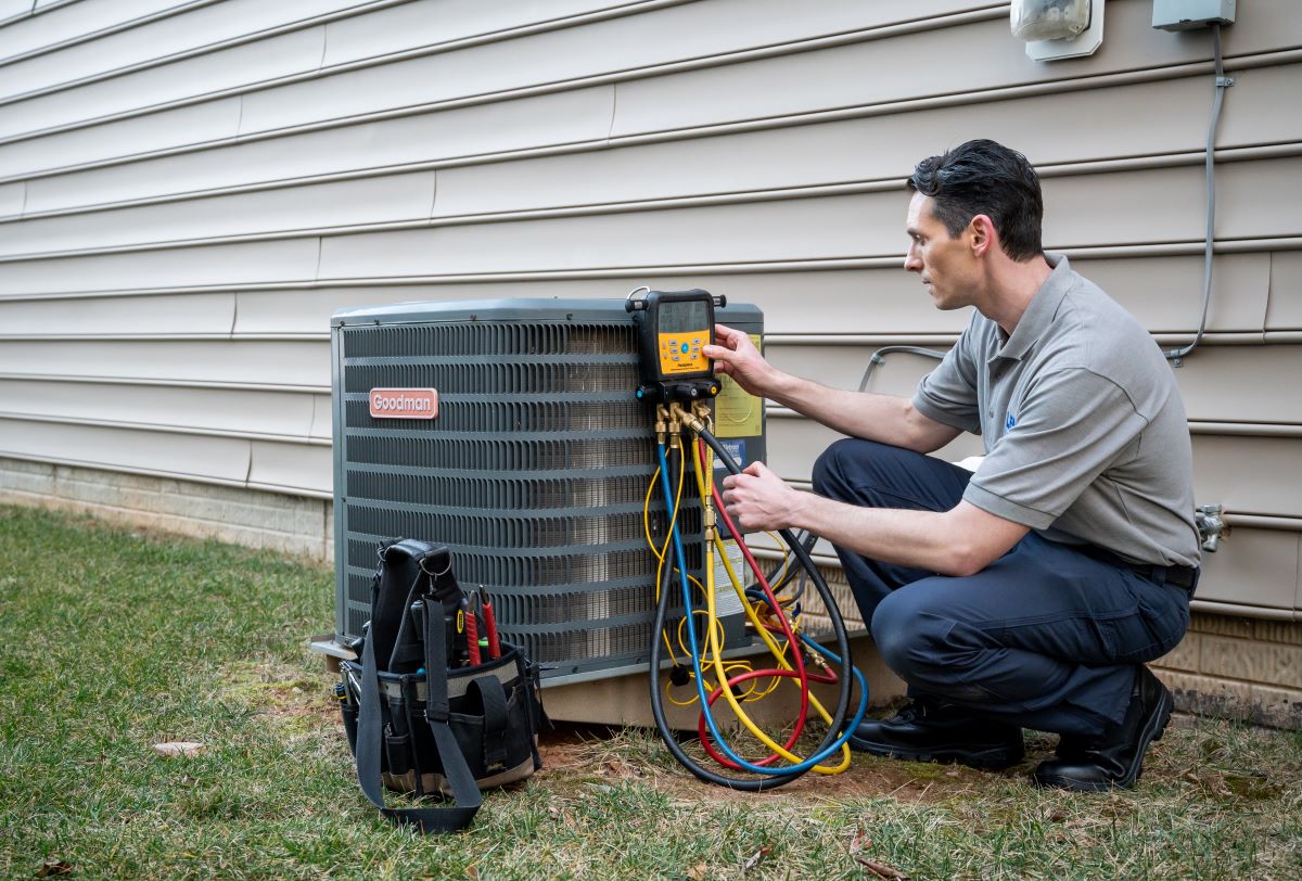 HVAC technician maintaining AC unit