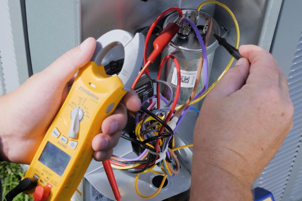 person working on wires for HVAC maintenance in Baltimore home