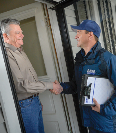 Len The Plumber technician smiling and shaking a customer's hand in a doorway at Philadelphia home.