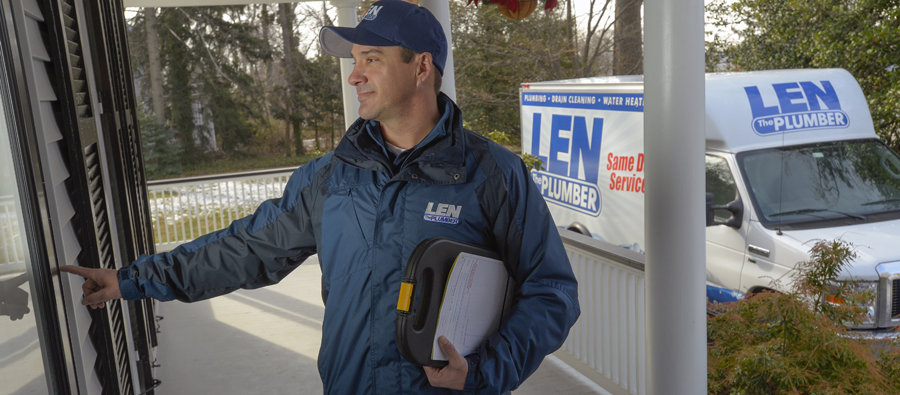 Len The Plumber technician ringing a doorbell outside of a Baltimore home.