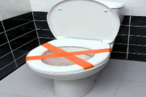 toilet with orange tape over seat